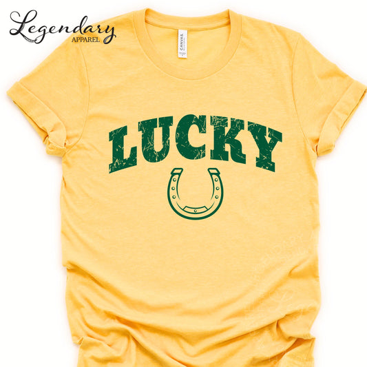 A yellow t-shirt with the word "Lucky" printed on it, along with a horseshoe graphic.