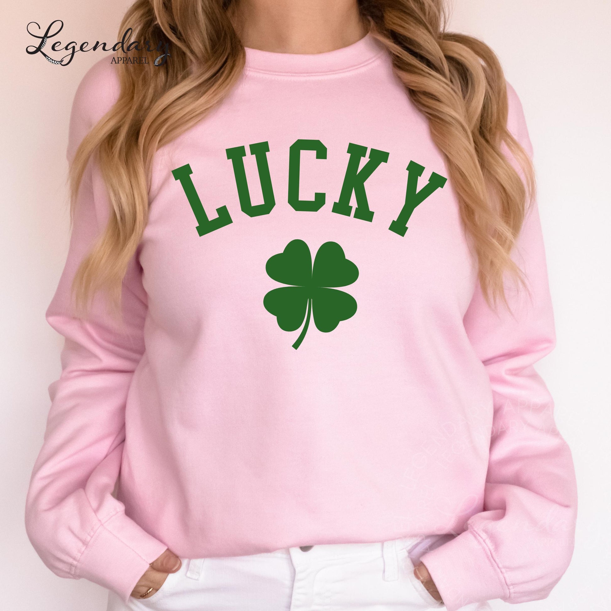 A woman wearing a pink sweatshirt with the word "Lucky" printed on it, along with a green clover symbol.