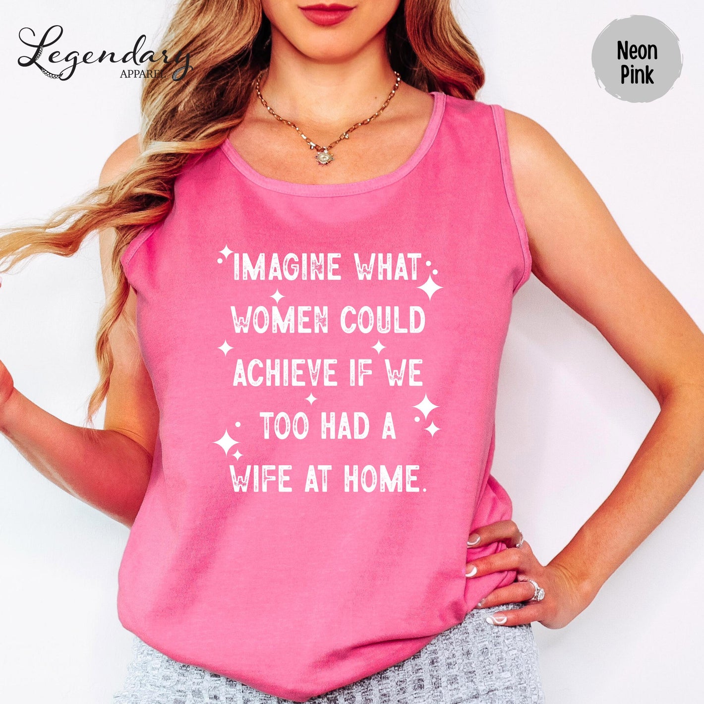 A woman wearing a pink tank top with white text on it.