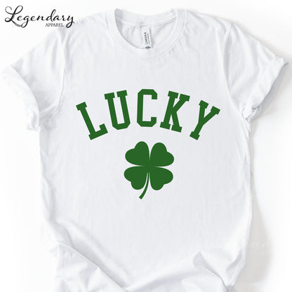 A white t-shirt with the word "Lucky" printed on it, along with a green clover symbol.