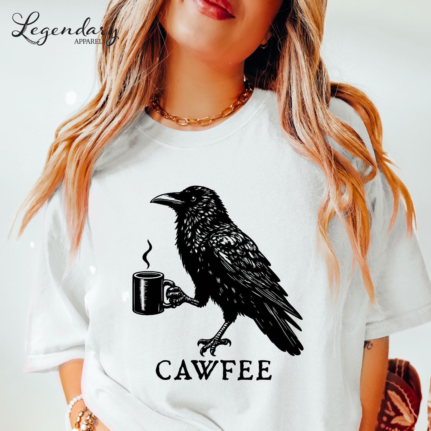 A woman wearing a white t-shirt with a black crow graphic and the text "CAWFREE" printed on it.