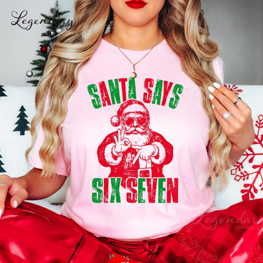A woman wearing a pink t-shirt with a graphic of Santa Claus and the text "Santa says six seven" is shown in the image.