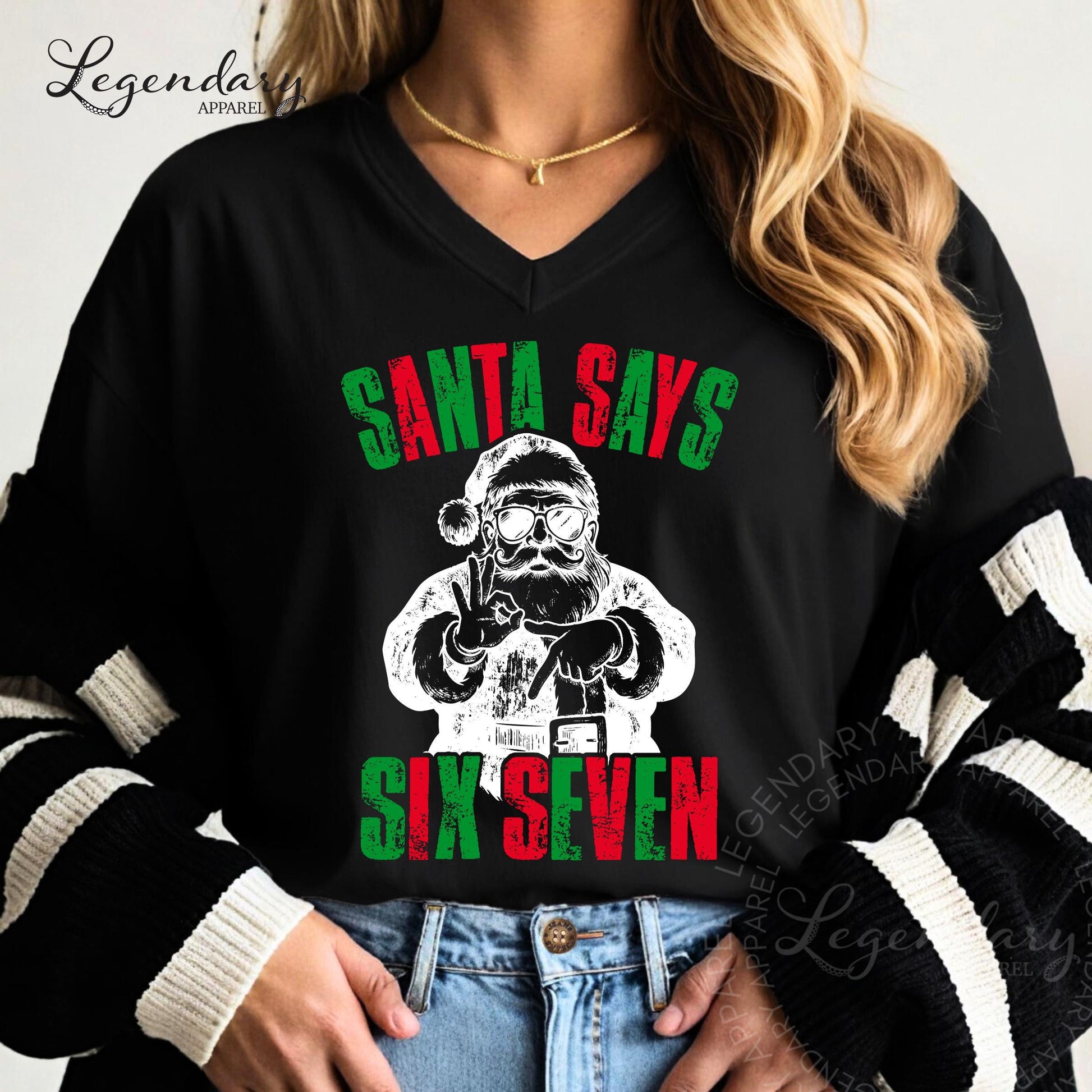 A person wearing a black shirt with a graphic design featuring a Santa Claus figure and the text &quot;Santa says six seven&quot;.