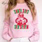 A woman wearing a pink sweatshirt with a graphic design of Santa Claus and the text &quot;Santa says six seven&quot; printed on it.