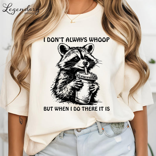 A person wearing a white t-shirt with a graphic design of a raccoon holding a coffee cup and the text "I DON'T ALWAYS WHOOP BUT WHEN I DO THERE IT IS".