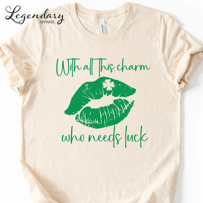 A beige t-shirt with a graphic design featuring green lips and a clover leaf, along with the text "With all this charm who needs luck".
