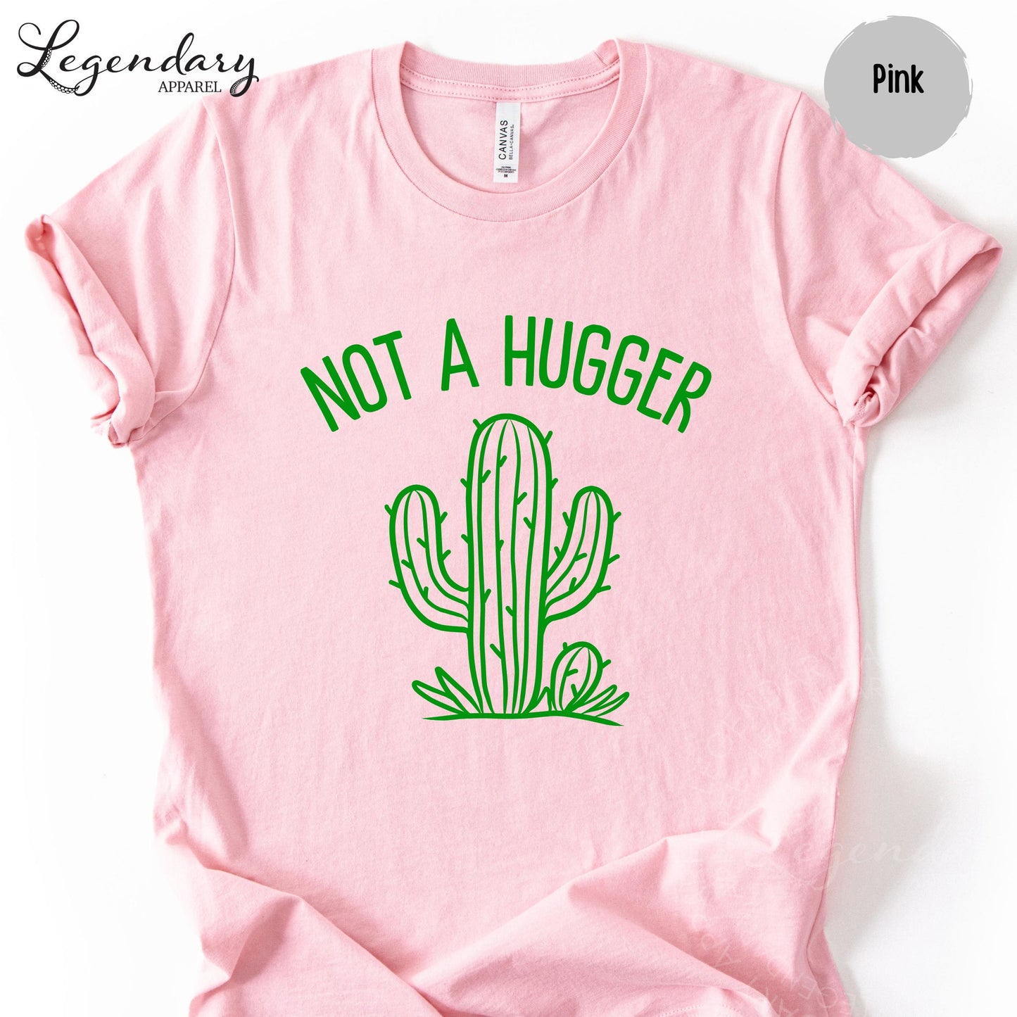 A pink t-shirt with a green graphic of a cactus and the text "NOT A HUGGER" printed on it.