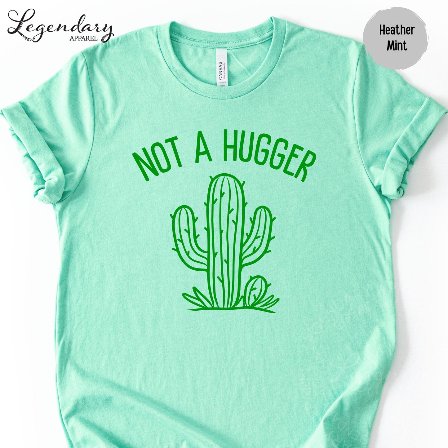 A mint green t-shirt with a graphic of a cactus and the text "NOT A HUGGER" printed on it.