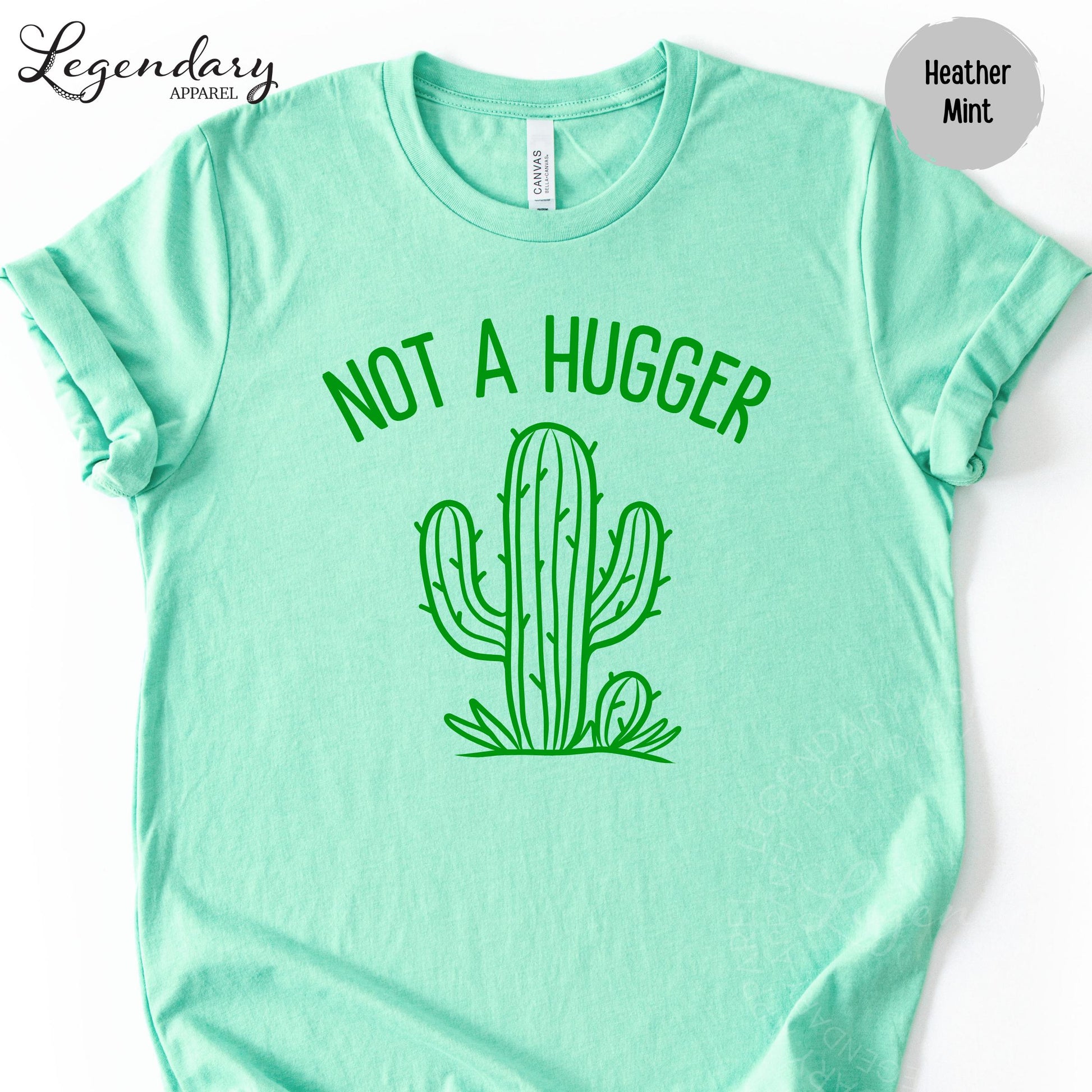 A mint green t-shirt with a graphic of a cactus and the text "NOT A HUGGER" printed on it.