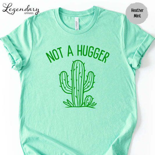 A mint green t-shirt with a graphic of a cactus and the text "NOT A HUGGER" printed on it.