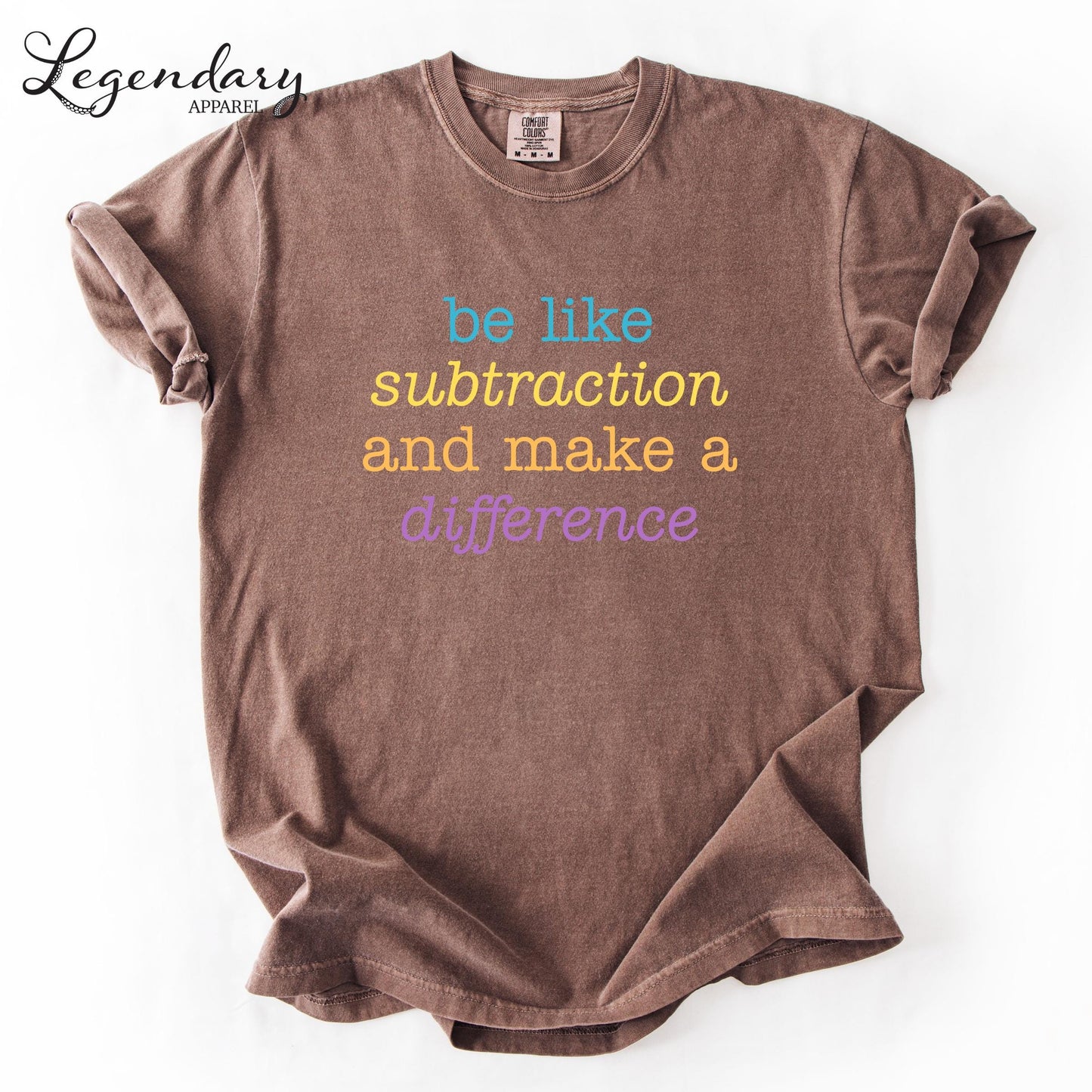 A brown t-shirt with the text "be like subtraction and make a difference" printed on it.