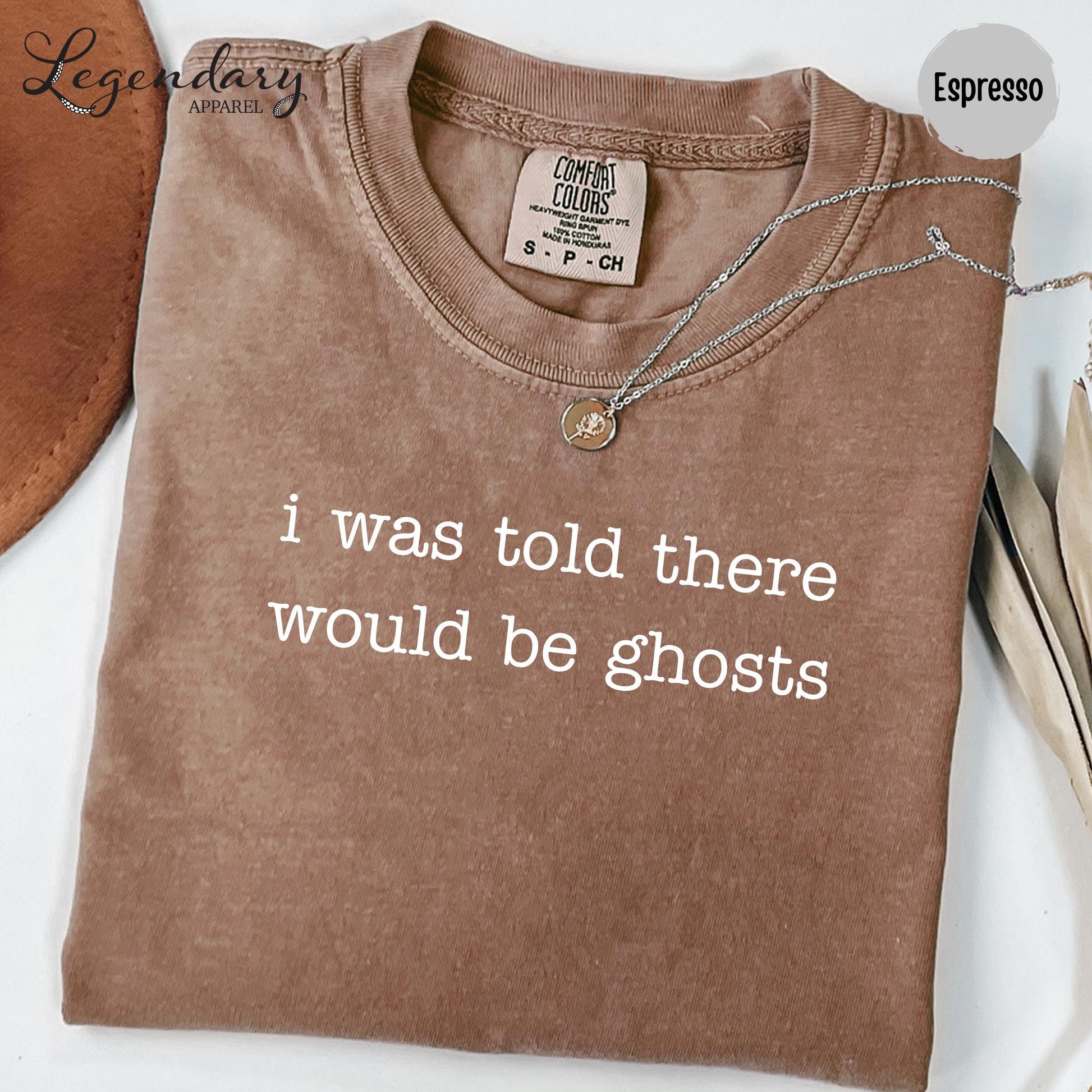 a brown t-shirt with the text "I was told there would be ghosts" printed on it.