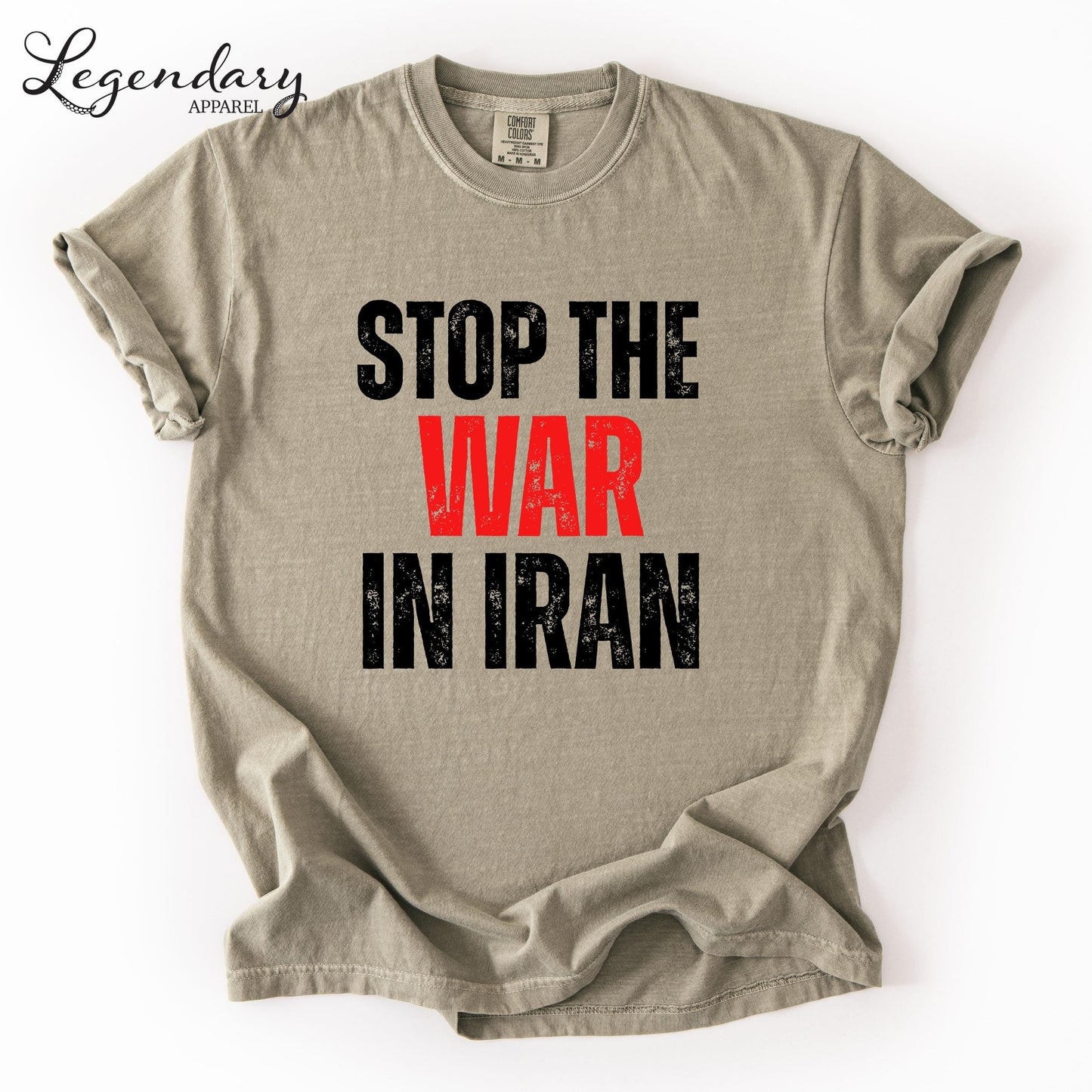 A beige t-shirt with the text "STOP THE WAR IN IRAN" printed on it in bold black letters.