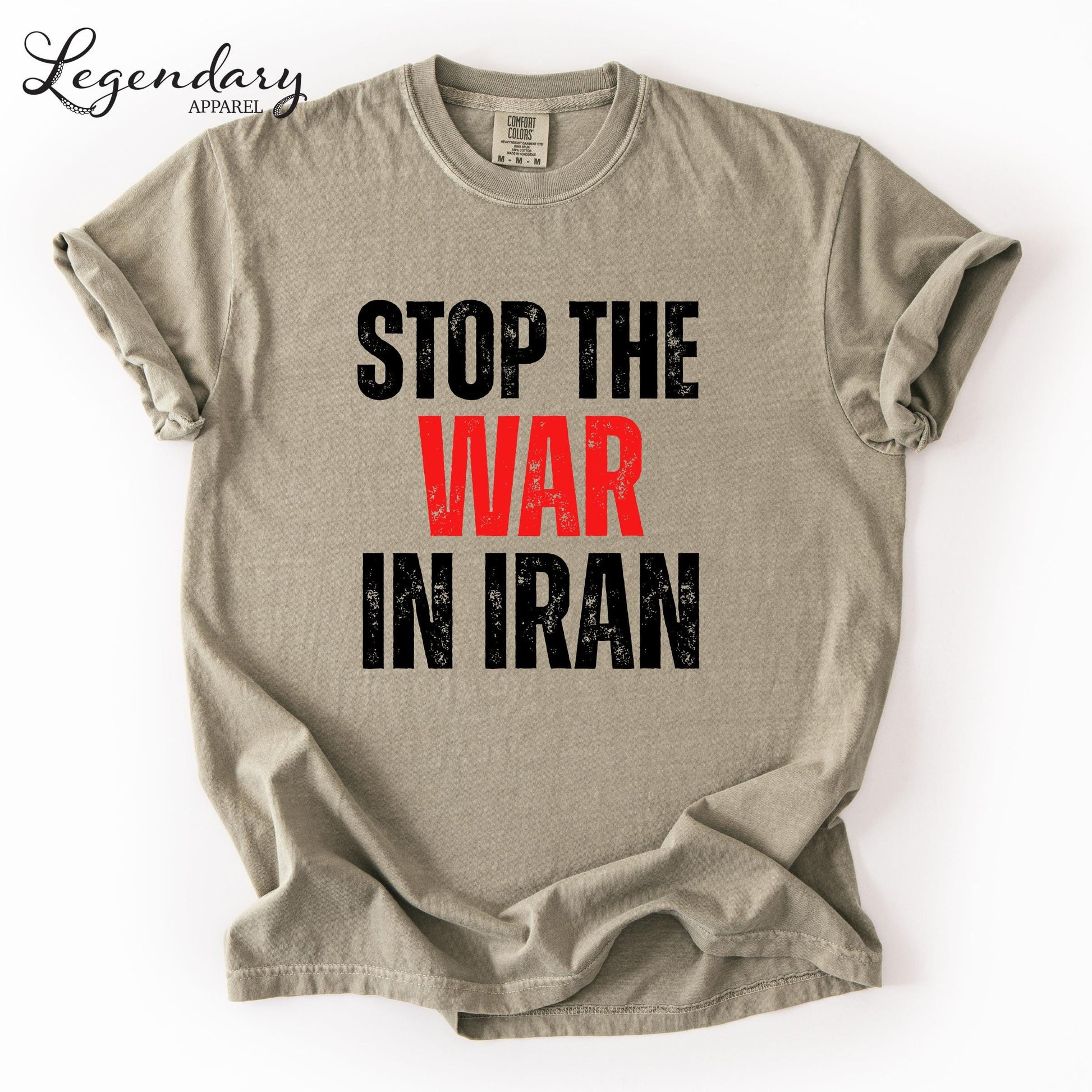 A beige t-shirt with the text "STOP THE WAR IN IRAN" printed on it in bold black letters.
