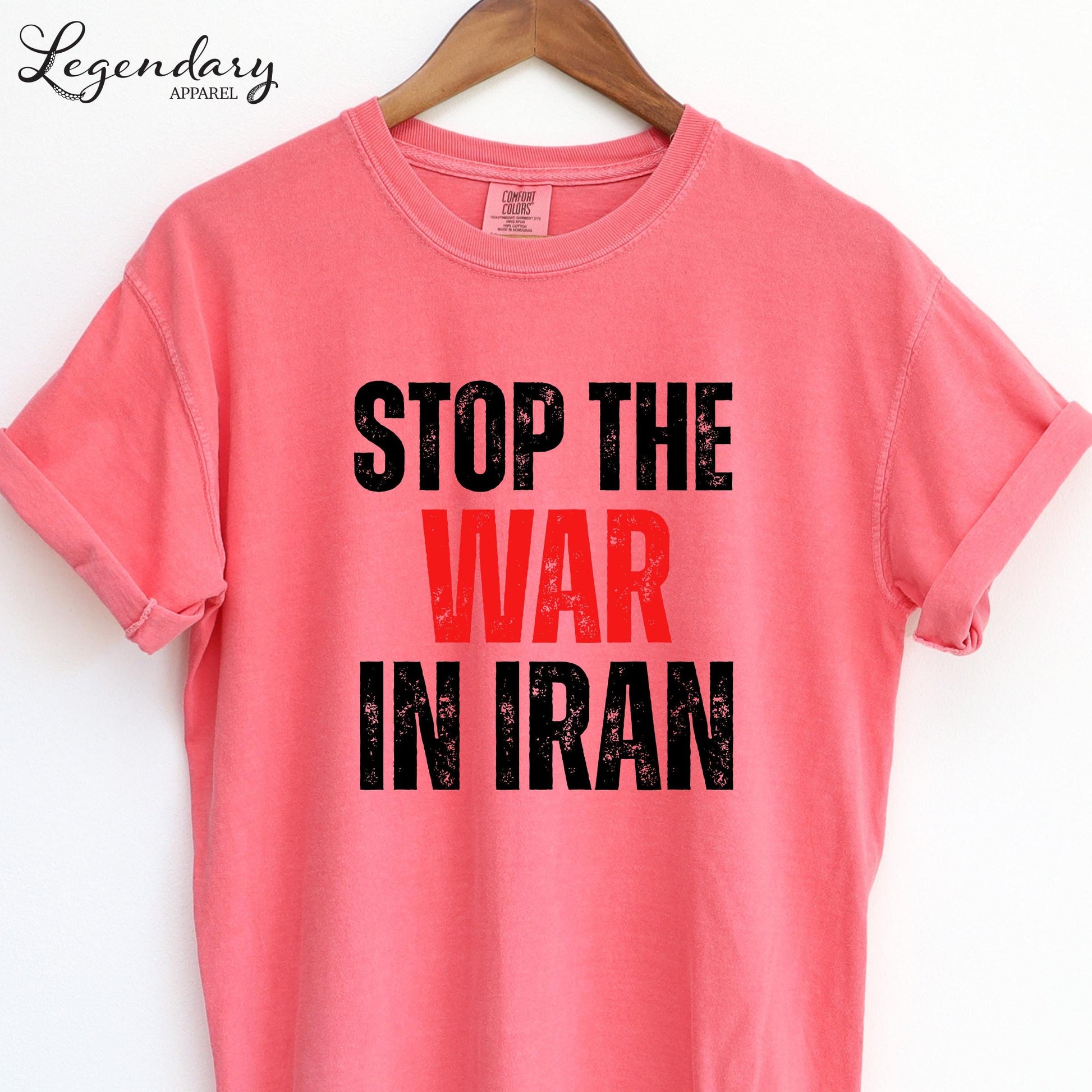 A pink t-shirt with the text "STOP THE WAR IN IRAN" printed on it.