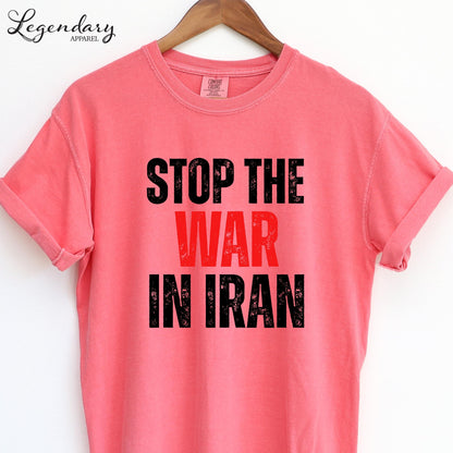 A pink t-shirt with the text "STOP THE WAR IN IRAN" printed on it.
