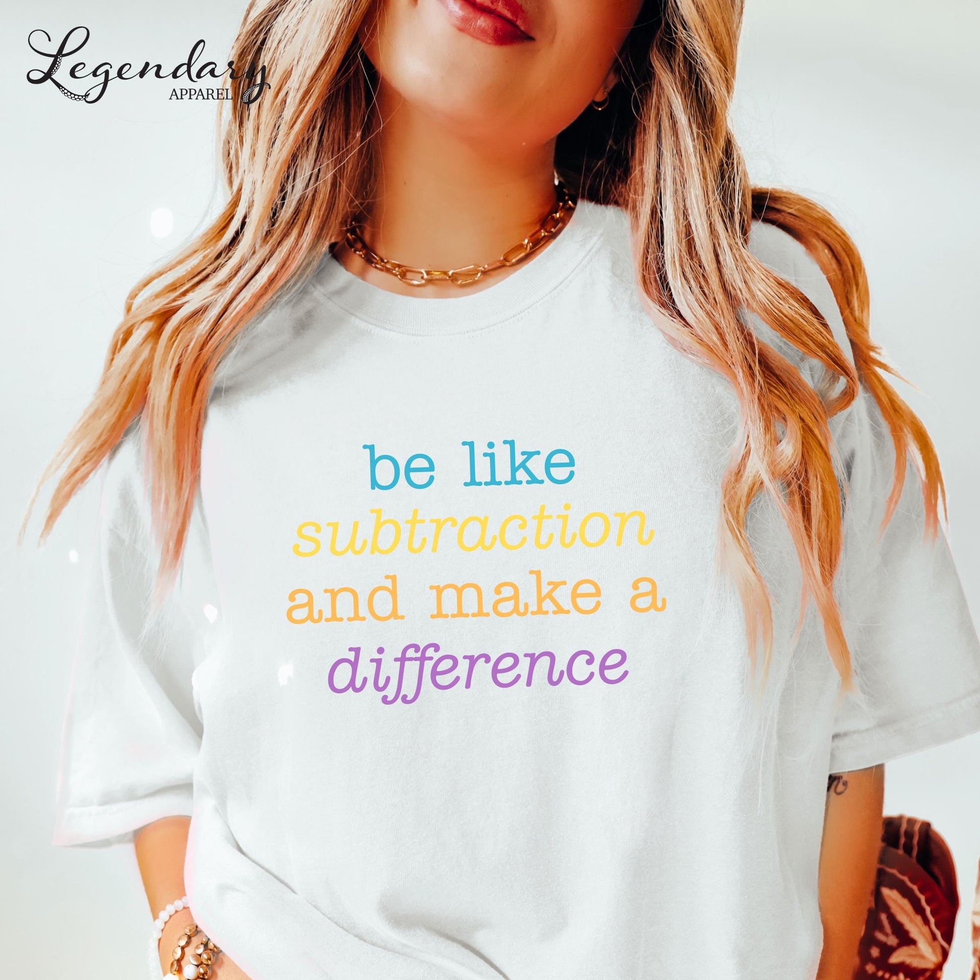 A woman wearing a white t-shirt with the text "be like subtraction and make a difference" printed on it.