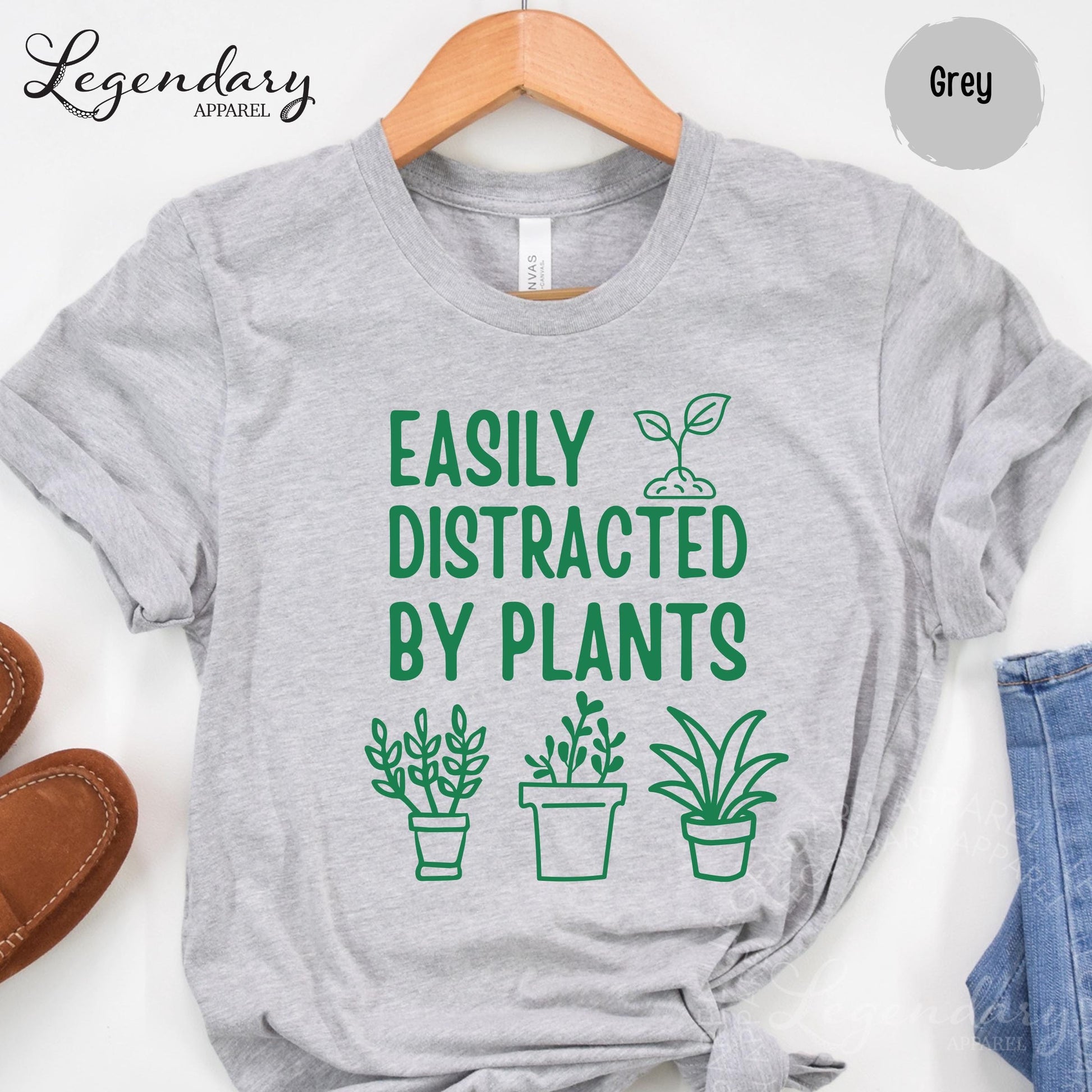 A grey t-shirt with a humorous text printed on it, along with three plant illustrations.