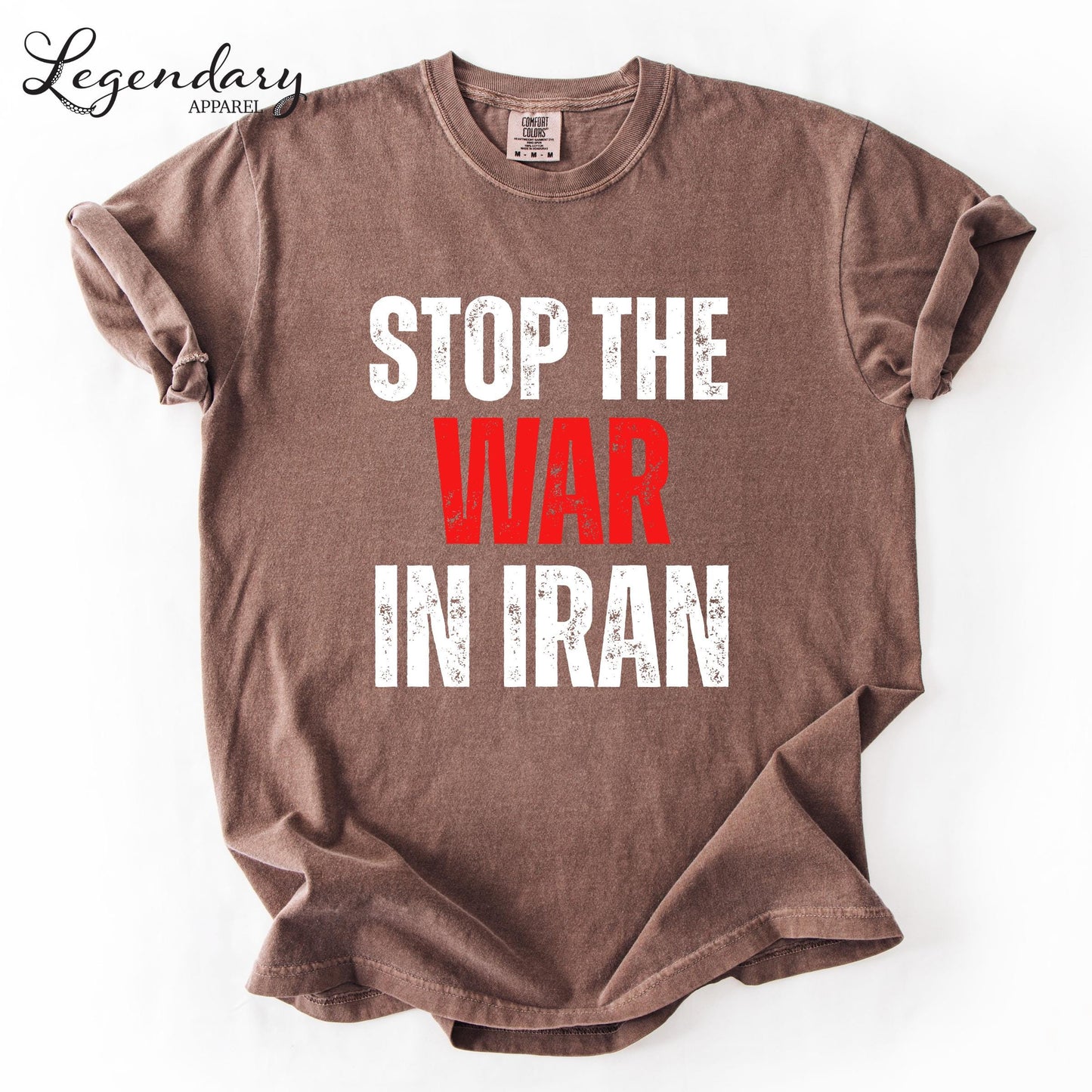 A brown t-shirt with the text "STOP THE WAR IN IRAN" printed on it in white and red lettering.