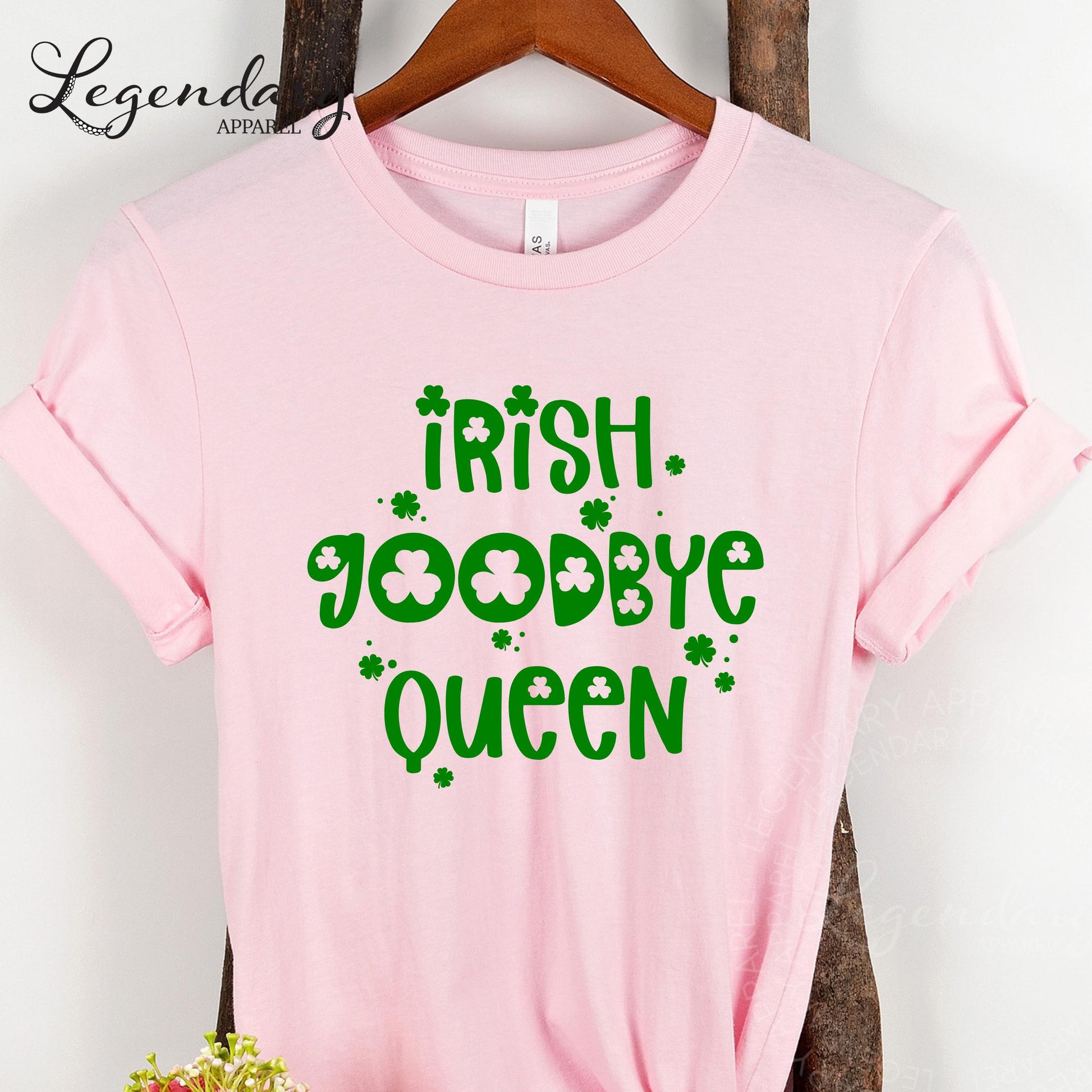 A pink t-shirt with the text "Irish Goodbye Queen" printed on it, along with shamrocks.