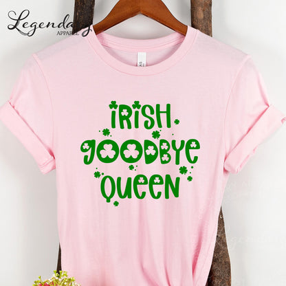 A pink t-shirt with the text "Irish Goodbye Queen" printed on it, along with shamrocks.