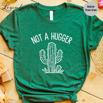 A green t-shirt with a white graphic of a cactus and the text "NOT A HUGGER" printed on it.