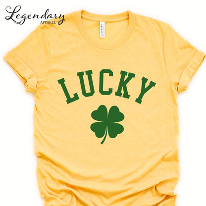 A yellow t-shirt with the word "Lucky" printed on it, along with a green clover symbol.