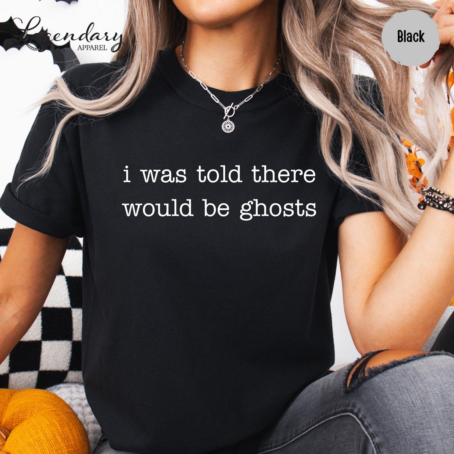 A person wearing a black t-shirt with the text "I was told there would be ghosts" printed on it.