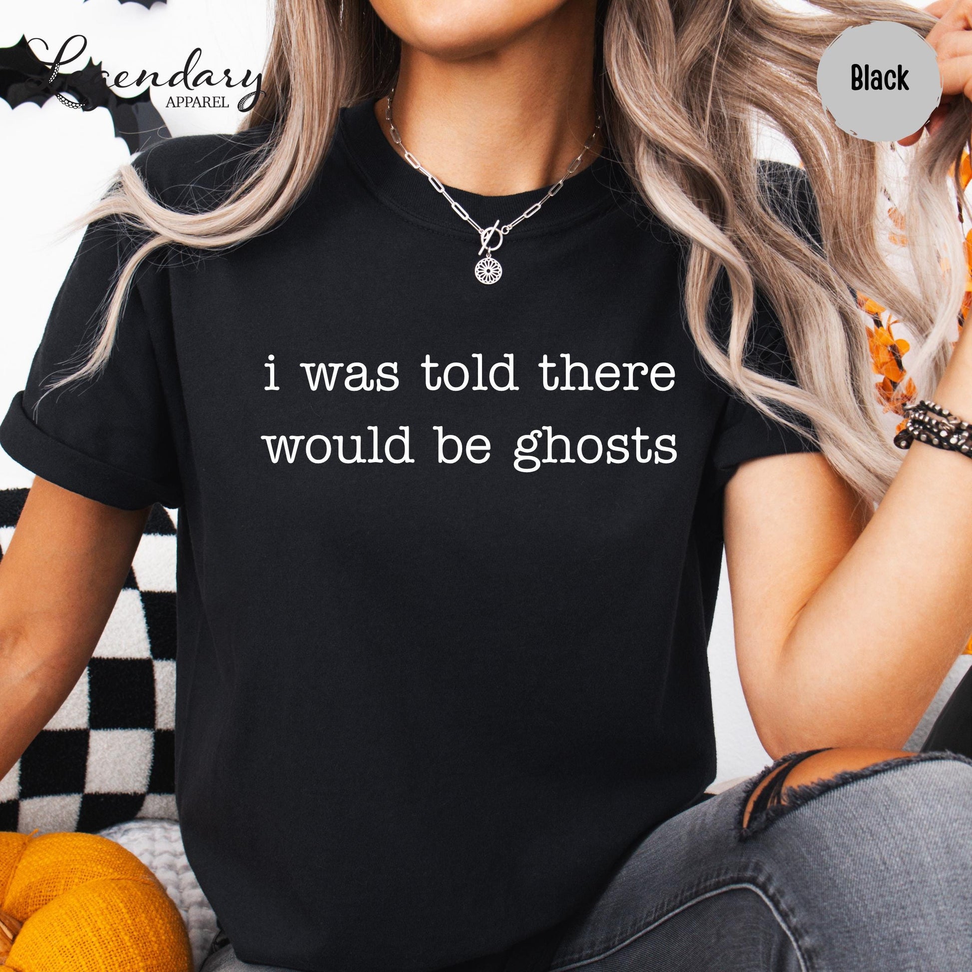 A person wearing a black t-shirt with the text "I was told there would be ghosts" printed on it.