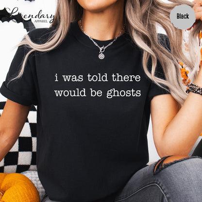 A person wearing a black t-shirt with the text "I was told there would be ghosts" printed on it.