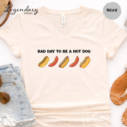 a white t-shirt with a graphic design of five hot dogs, accompanied by the text "Bad day to be a hot dog".