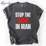 A gray t-shirt with the text "STOP THE WAR IN IRAN" printed on it in white and red lettering.