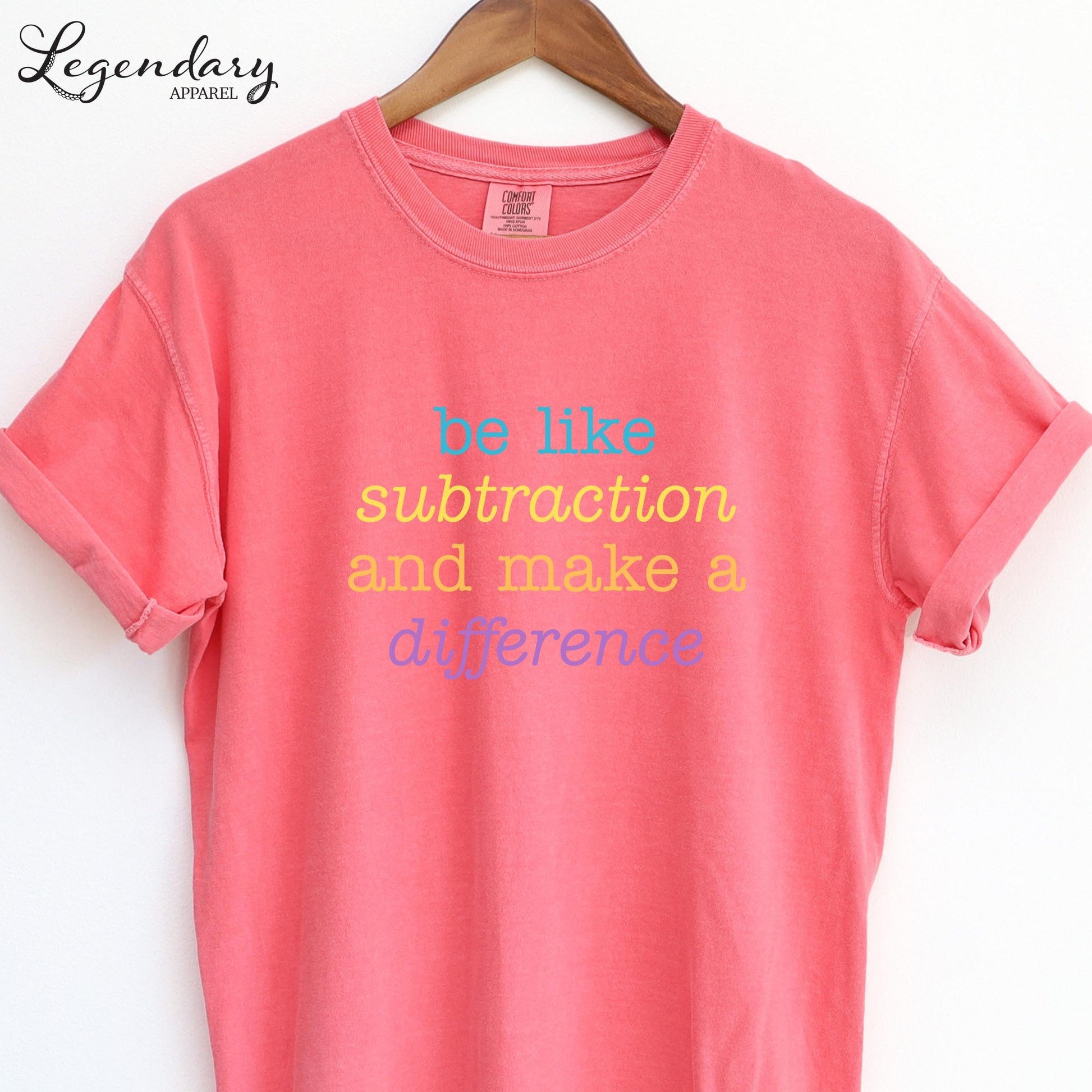 A pink t-shirt with the text "be like subtraction and make a difference" printed on it.