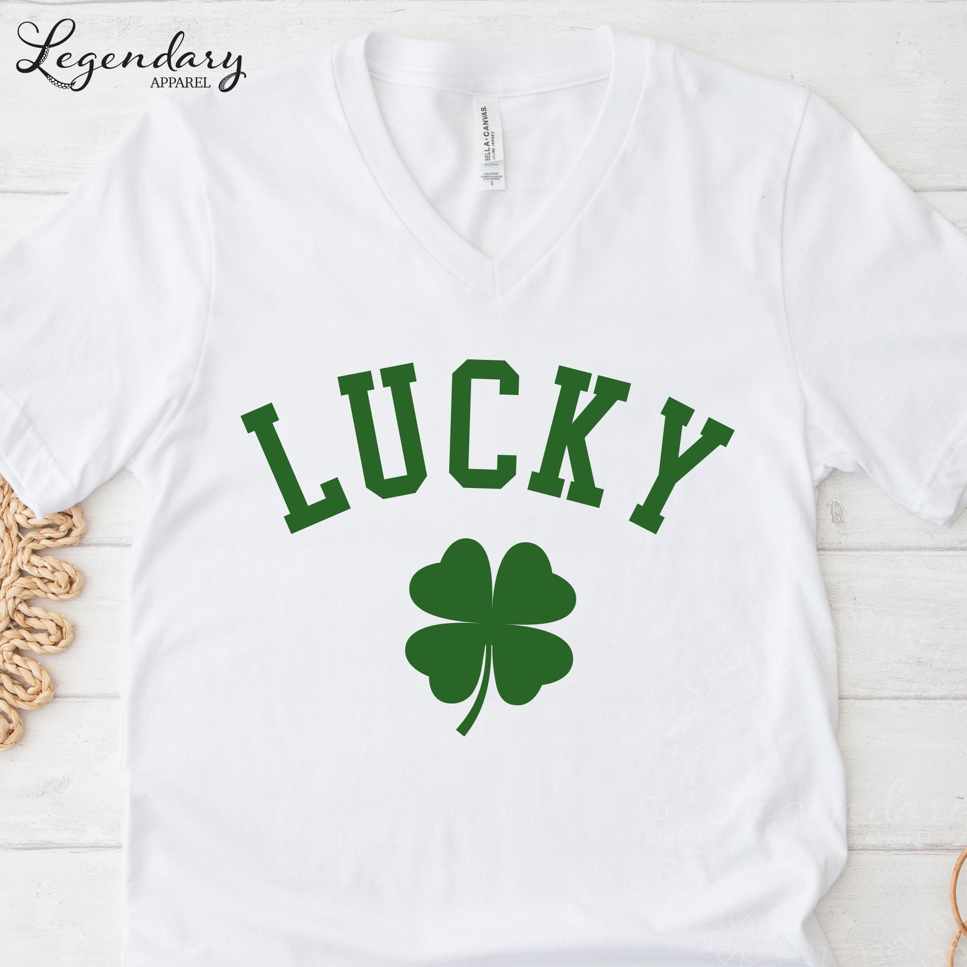 A white t-shirt with the word "Lucky" printed on it, along with a green clover symbol.